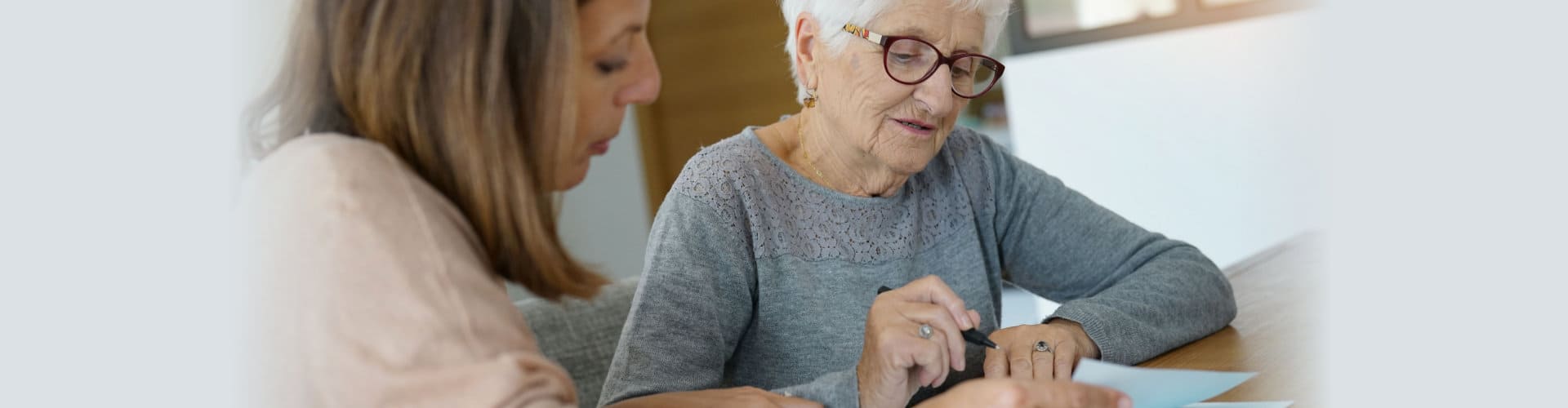 home assistant helping elderly woman with paper work