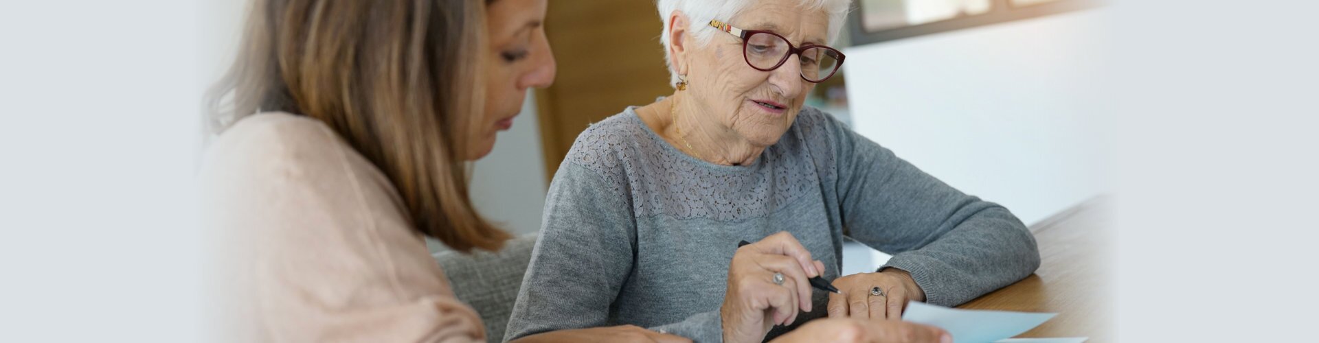 home assistant helping elderly woman with paper work