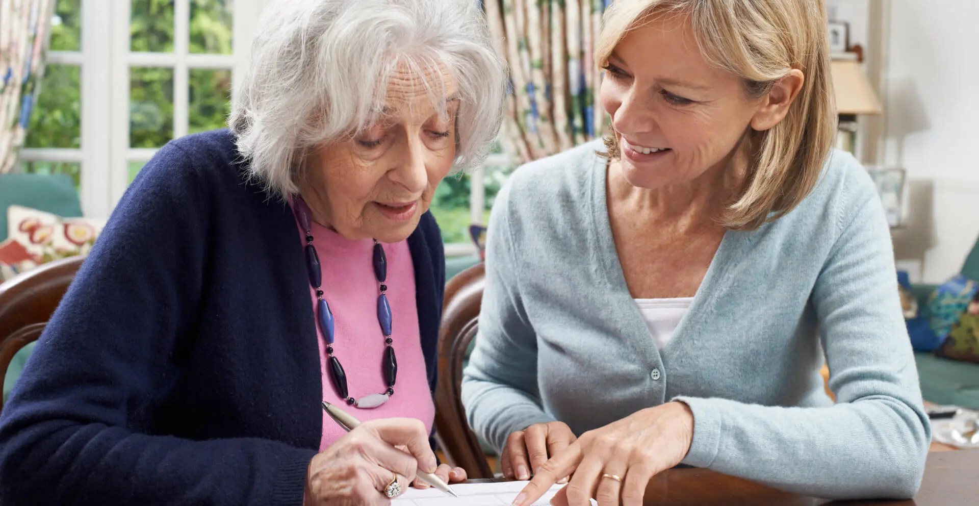 caregiver helping senior woman to complete form