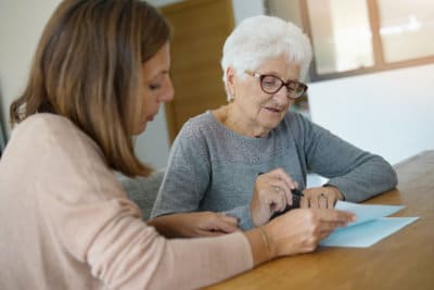 home assistant helping elderly woman with paper work